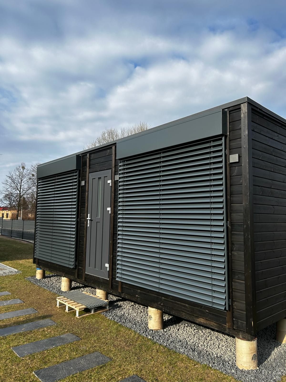 Fasādes lameļu žalūzijas uz tumšas moduļu mājas — FENSTORA, Rīga