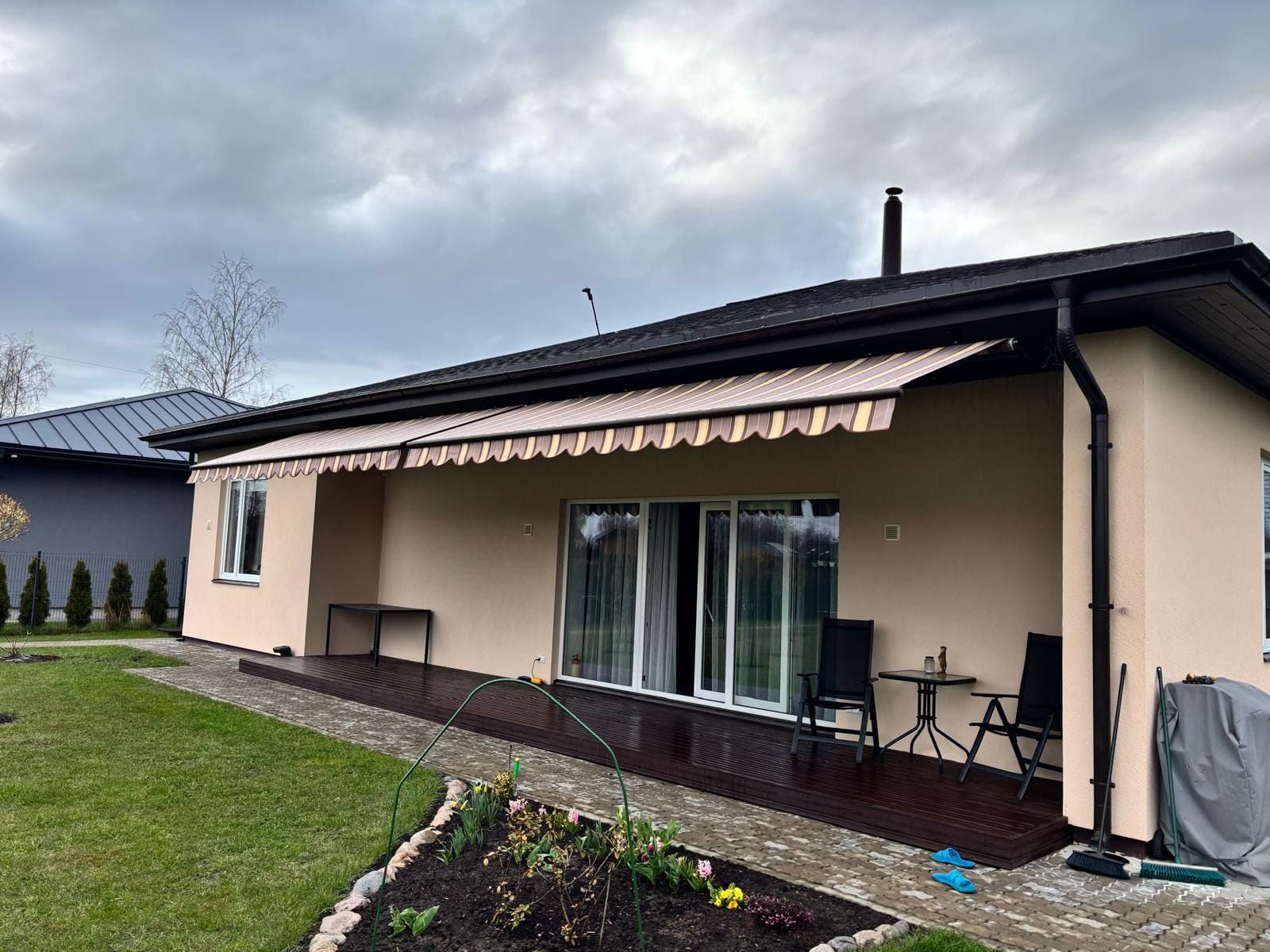 Izvelkama markīze pār privātmājas terasi, gaišs svītrots audums — FENSTORA, Rīga