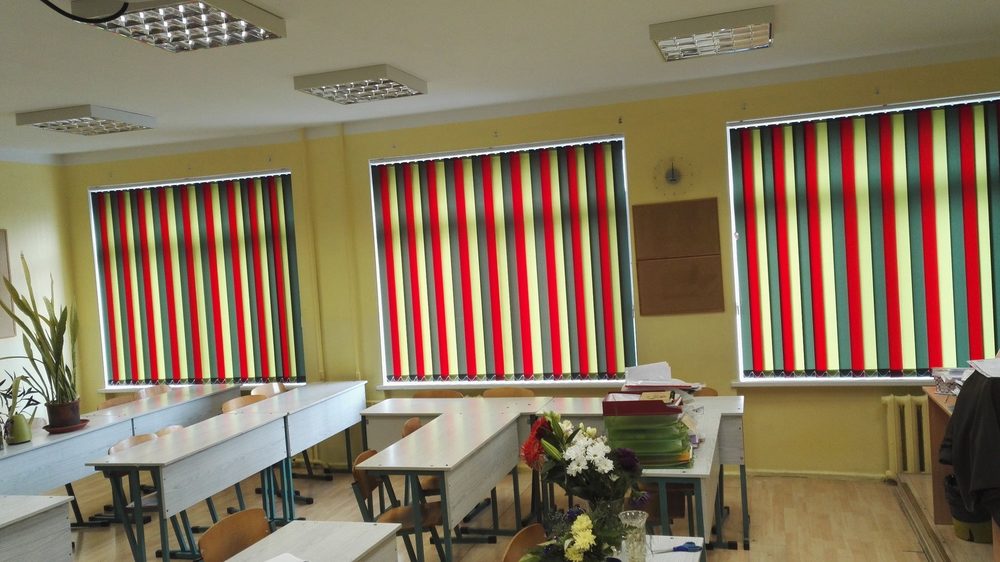 Krāsainas svītrotas vertikālās žalūzijas skolas klasē