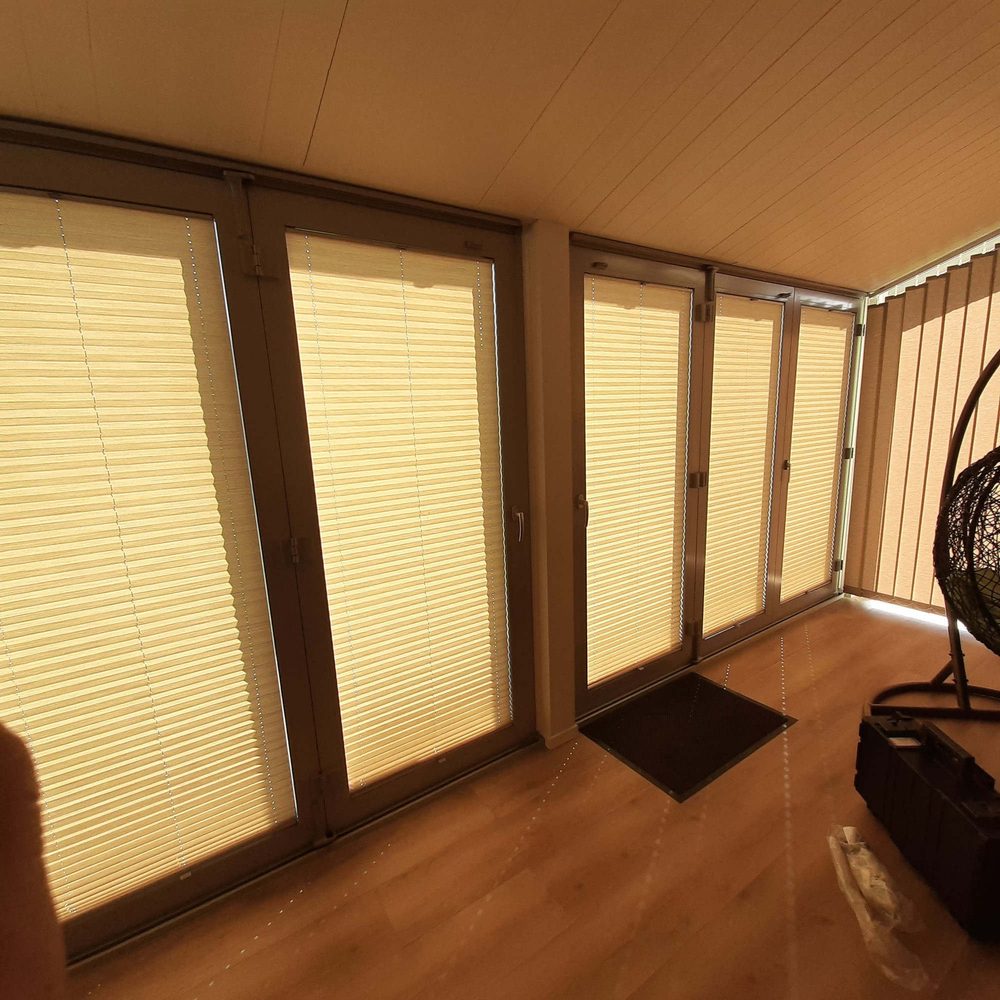Bēšas plisētās žalūzijas uz panorāmas verandas